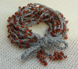 Beaded crocheted grey and red bracelet
